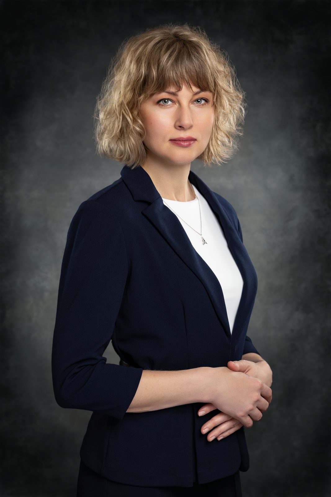 Premium business portrait of a professional woman wearing a dark blue blazer in Austin Texas