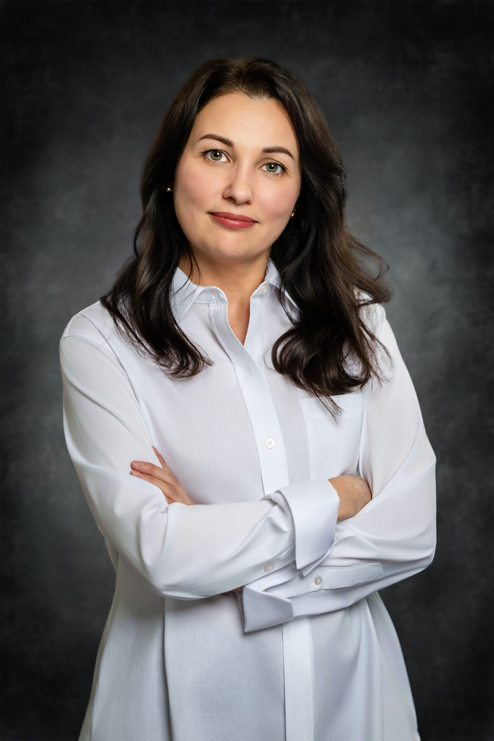 April_22_2026_20_22_30_Vlad_Mixer_Austin_Texas_Photographer Executive business headshot of a smiling woman with folded arms demonstrating sharp studio lighting