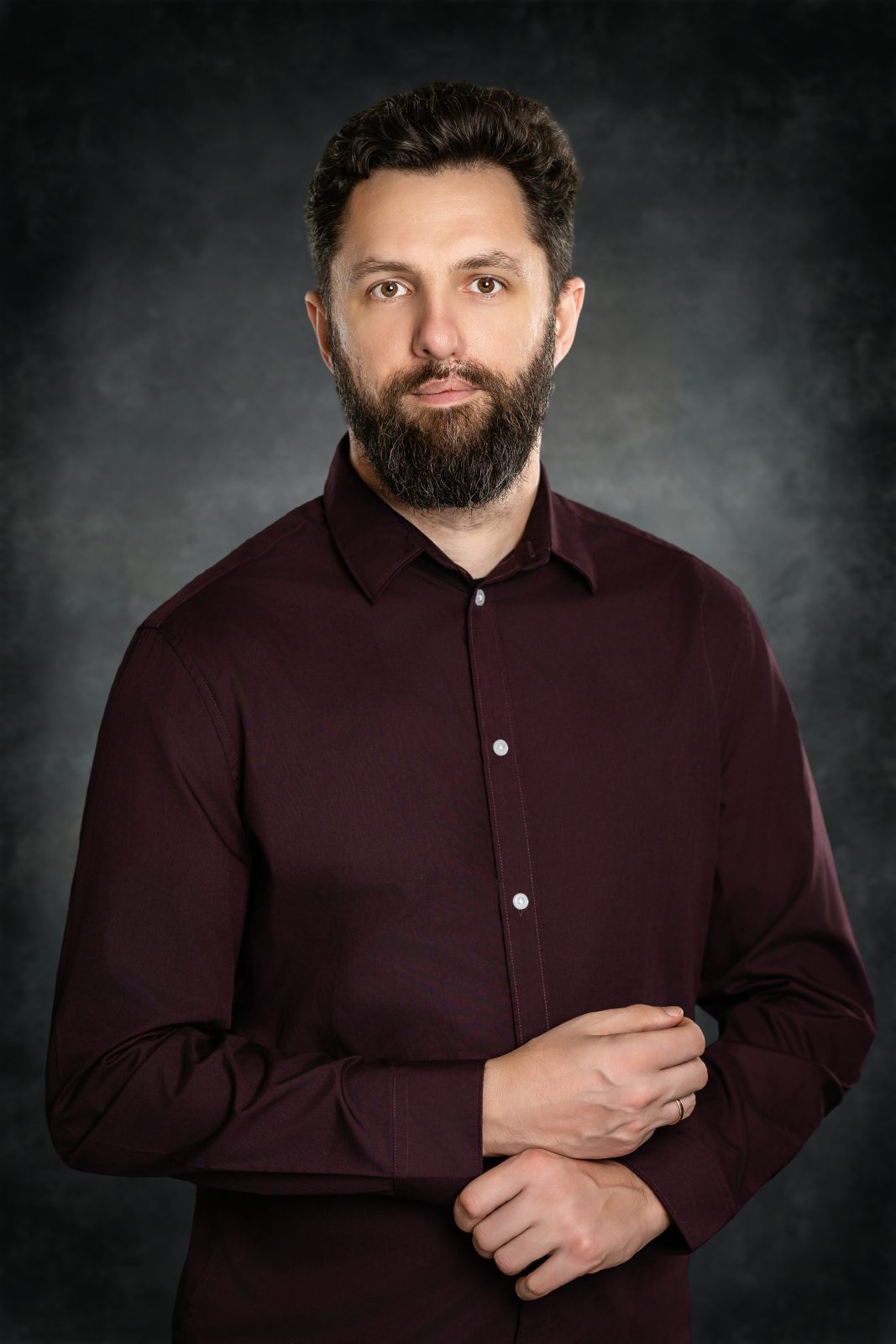 Professional corporate portrait of a bearded man in a burgundy shirt perfect for company website team page